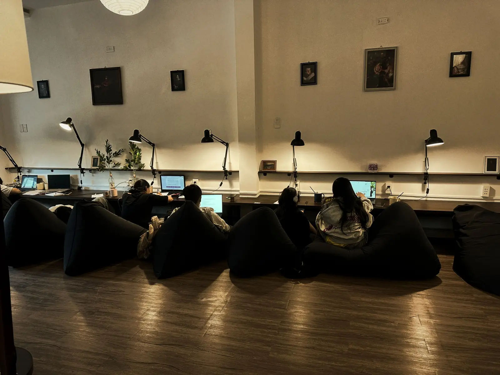 Chốn Riêng Liên Chiểu buổi tối: dãy đèn bàn dọc tường, lồng đèn giấy, vài người ngồi ghế lười quay lưng làm bài